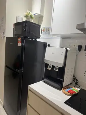 a kitchen with a printer on a counter next to a refrigerator at The Horizon Ipoh by Amris in Ipoh