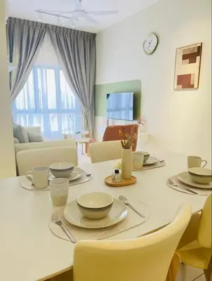 a table with plates and bowls on it in a living room at The Horizon Ipoh by Amris in Ipoh