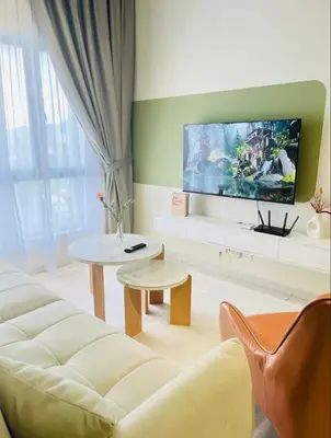 a living room with a couch and a flat screen tv at The Horizon Ipoh by Amris in Ipoh