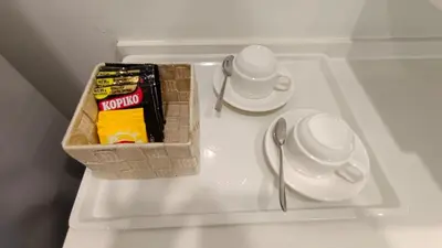 a white table with a basket on top of a table with plates and cups at Straits Garden Penang 2BR in Jelutong