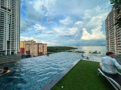 a infinity pool on a building with people in the water at Le Jardin Suite 8 Pax Sea View Infinity Pool in George Town