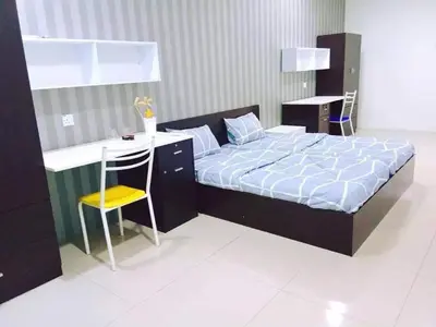 a bedroom with a bed and a desk and a chair at The Suncity Inn in Kampar