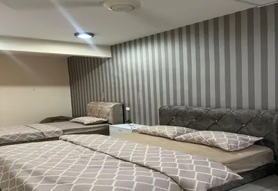 a bedroom with two beds and a couch at The Suncity Inn in Kampar