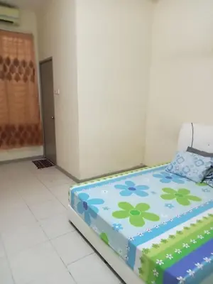 a room with a bed with a flower pattern on it at Hani Homestayz2U in Kuala Lipis