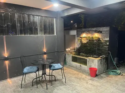 a patio with a table and chairs and a fireplace at Nafisa Homestay in Kepala Batas