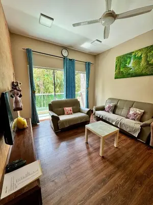 a living room with two couches and a table at Ayaan Bliss Homestay at QuintetTanahRata in Cameron Highlands