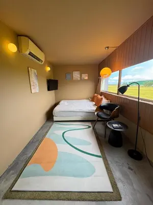 a bedroom with a bed and a large rug at PadiBox Homestay in Sekincan