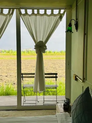 a room with a window with a chair on a porch at PadiBox Homestay in Sekincan
