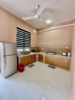 a large kitchen with a refrigerator and a window at Homestay Selesa KPP Guest House in Gua Sai