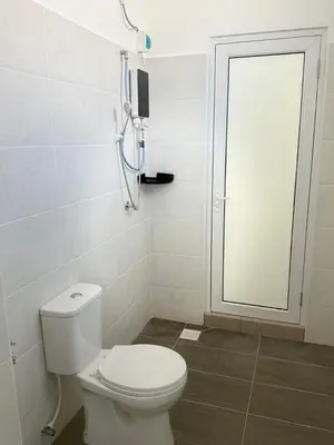 a bathroom with a white toilet and a window at Classic Home Stay in Kuala Ketil