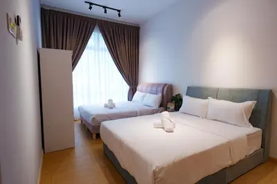 a bedroom with two beds and a window at Mahkota Valley Suites Kuantan by Iconique in Gua Sai