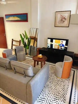 a living room with a couch and chairs and a tv at Courtyard by Heritage Row in George Town