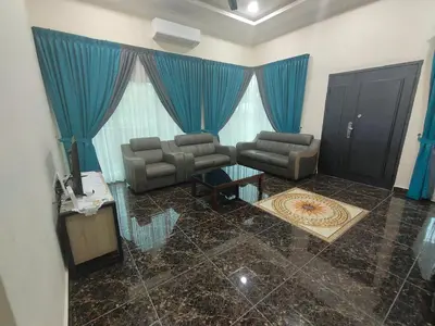 a living room with couches and a blue curtain at SUN HOMESTAY Teluk Intan