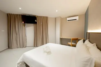 a hotel room with a white bed and a television at M Spice Hotel Seberang Jaya in Perai