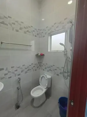 a white bathroom with a toilet and a sink at SUN HOMESTAY Teluk Intan