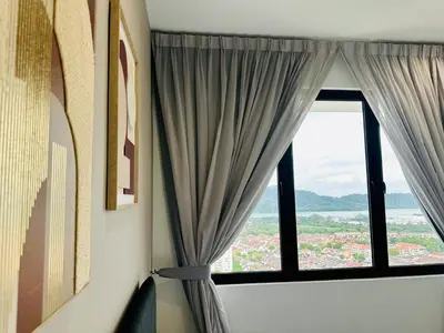 a room with a window with curtains and a view at Luxury Sky Stay Sea & Penang Bridge View in Bayan Lepas