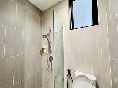a bathroom with a shower and a toilet and a window at Luxury Sky Stay Sea & Penang Bridge View in Bayan Lepas