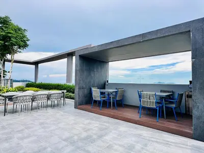 a patio with tables and chairs on a deck at High Floor Sea View Penang Bridge Luxury 2BR in Bayan Lepas