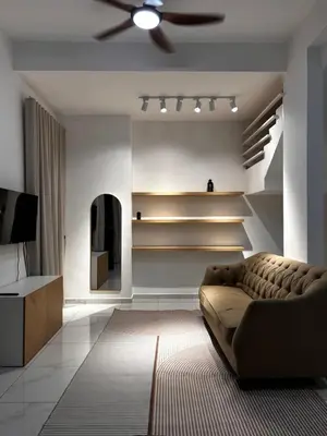 a living room with a couch and a ceiling fan at Villa Natura ByTheNook in Sungai Petani