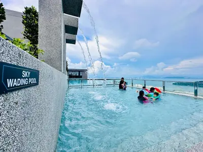 a group of people playing in a swimming pool at Luxury 2BR Rooftop Infinity Pool 8 Pax airport usm in Bayan Lepas