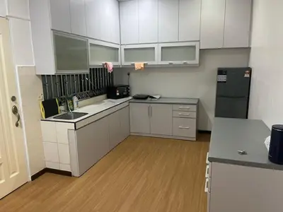 a kitchen with white cabinets and a black refrigerator at LIY Homestay in Gua Sai