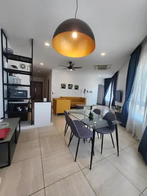 a dining room and living room with a table and chairs at The Octagon Ipoh - City Centre Premium Stay in Ipoh