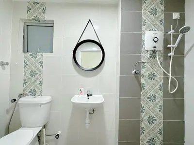a bathroom with a toilet sink and a mirror at The Anderson Cozy Deluxe Homestay in Ipoh