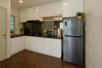 a kitchen with a stainless steel refrigerator and white cabinets at Salam Comfy Suite at Bandar Meru Raya Ipoh in Ipoh