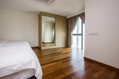 a bedroom with a white bed and a wooden floor at Sunrise Gurney Georgetwon in George Town