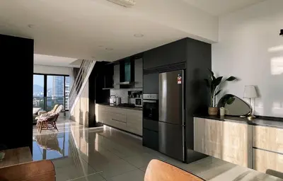 a kitchen with black cabinets and a stainless steel refrigerator at Sunrise Gurney Georgetwon in George Town