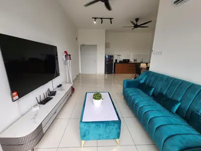 a living room with a blue couch and a tv at Horizon Rooftop Skypool Condotel - Ipoh in Ipoh