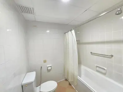 a white bathroom with a toilet and a bath tub at Penang Rainbow Paradise in Tanjung Bungah