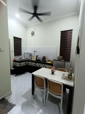 a kitchen with a table and a ceiling fan at Airisafiq Homestay in Kampong Sungai Rambai