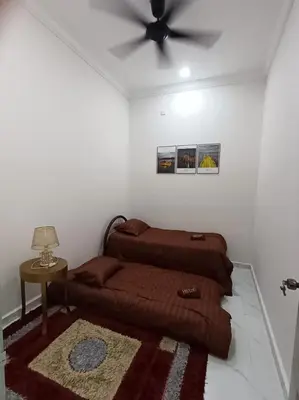 a bedroom with a bed and a ceiling fan at Airisafiq Homestay in Kampong Sungai Rambai