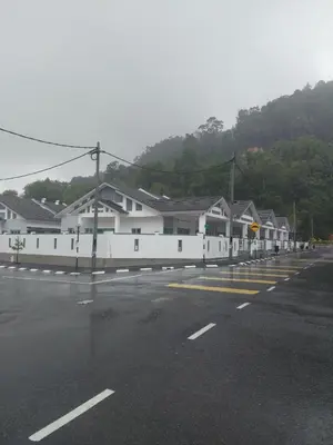 a row of white houses next to a parking lot at Naryan Homestay Teluk Batik in Lumut