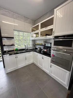 a large kitchen with white cabinets and appliances at The Nest Retreat, B7-3A-1 2BR Family Suite in Bukit Fraser