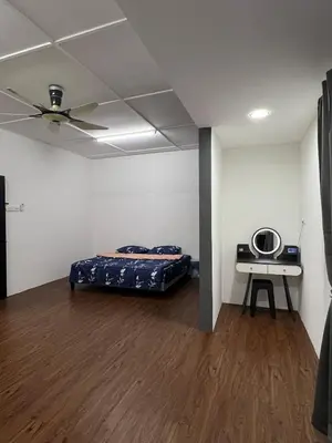 a room with a bed and a table in it at Classic Pearl Homestay in Teluk Intan