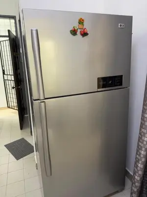 a stainless steel refrigerator in a kitchen with magnets on it at Austin Taman Daya Large Corner House for 10 Pax in Gua Sai