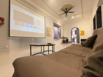a large screen in a living room with a couch at Austin Taman Daya Large Corner House for 10 Pax in Gua Sai