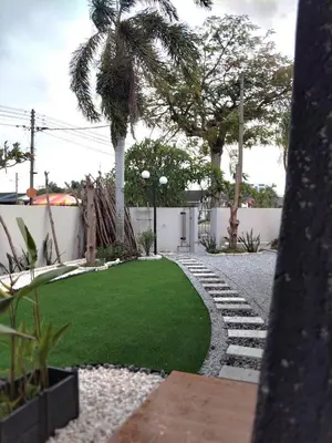 a garden with a palm tree and a lawn at Morikoi Cottage in Ipoh