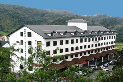 a large white building with cars parked in front of it at Hotel Titiwangsa in Gua Sai