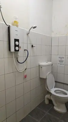 a bathroom with a white toilet and a shower at POLI Homes in George Town