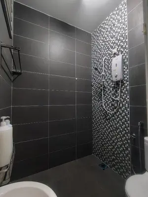 a bathroom with a shower with black tiles at Cozy Corner Homestay Bandar Utama Gua Musang in Gua Musang