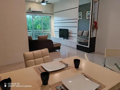 a dining room with a table and a living room at Sky Garden Luxury Family Stay in Ipoh