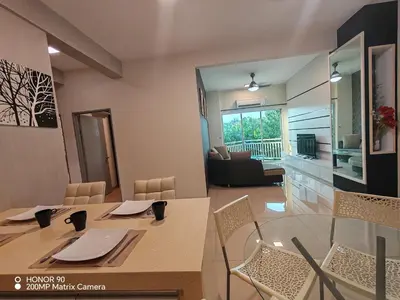 a dining room and living room with a table and chairs at Sky Garden Luxury Family Stay in Ipoh