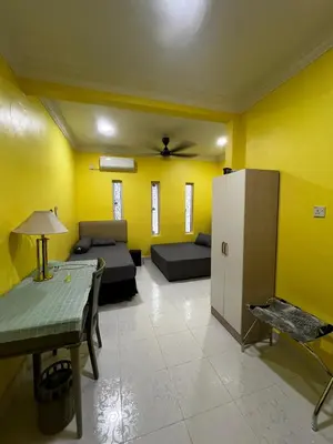 a living room with yellow walls and a couch and a table at Teratak Minda Cerdas in Kulim