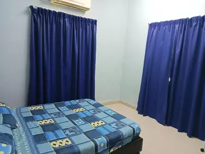 a bedroom with blue drapes and a bed in a room at HaniHomestay4U in Kuala Lipis