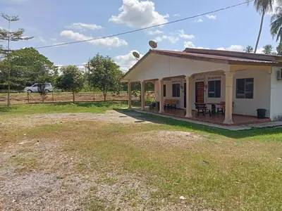 a small white house with a porch and a yard at HaniHomestay4U in Kuala Lipis