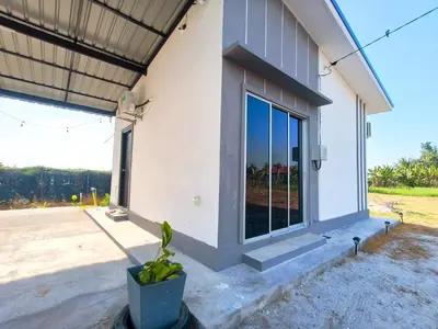 a house with a window and a potted plant at White House Villa in Sekincan