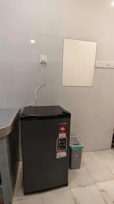 a black refrigerator in a room with a wall at DouDou's House in Simpang Ampat